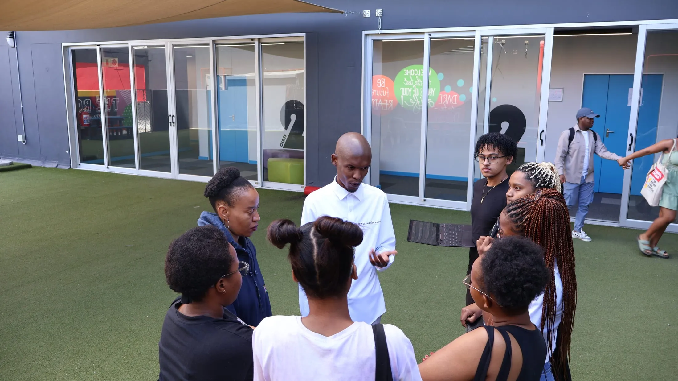 Tshepo Blom of Lumko in conversation with a group of students outdoors at IIE Rosebank College.